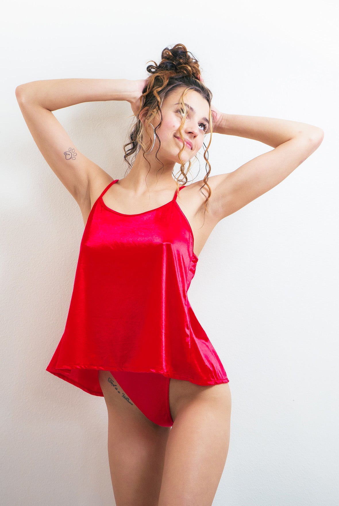 Red satin thong panties with narrow side straps and high-cut leg openings.