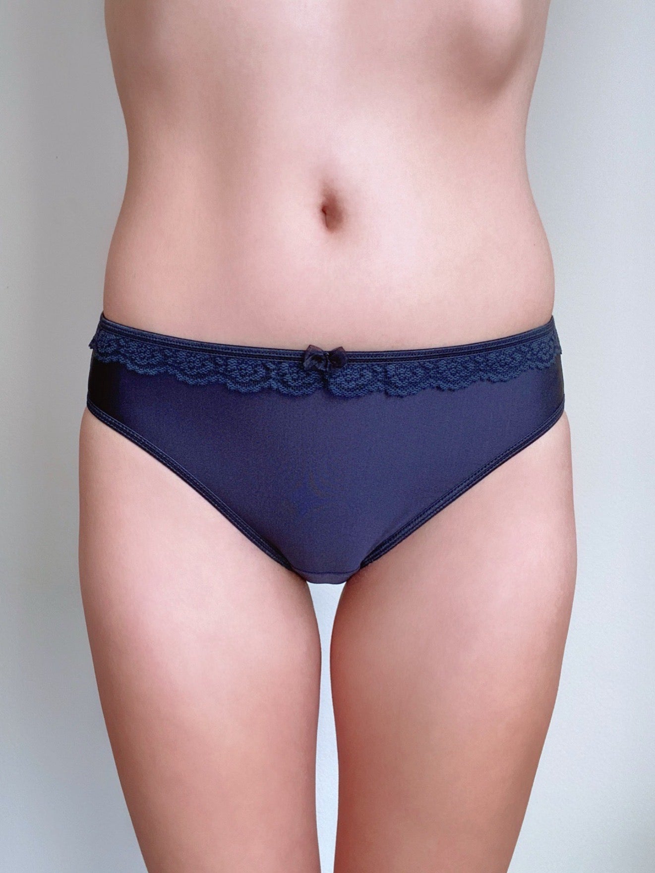 Front view of lace-trim brief panties with bow detail, dark blue