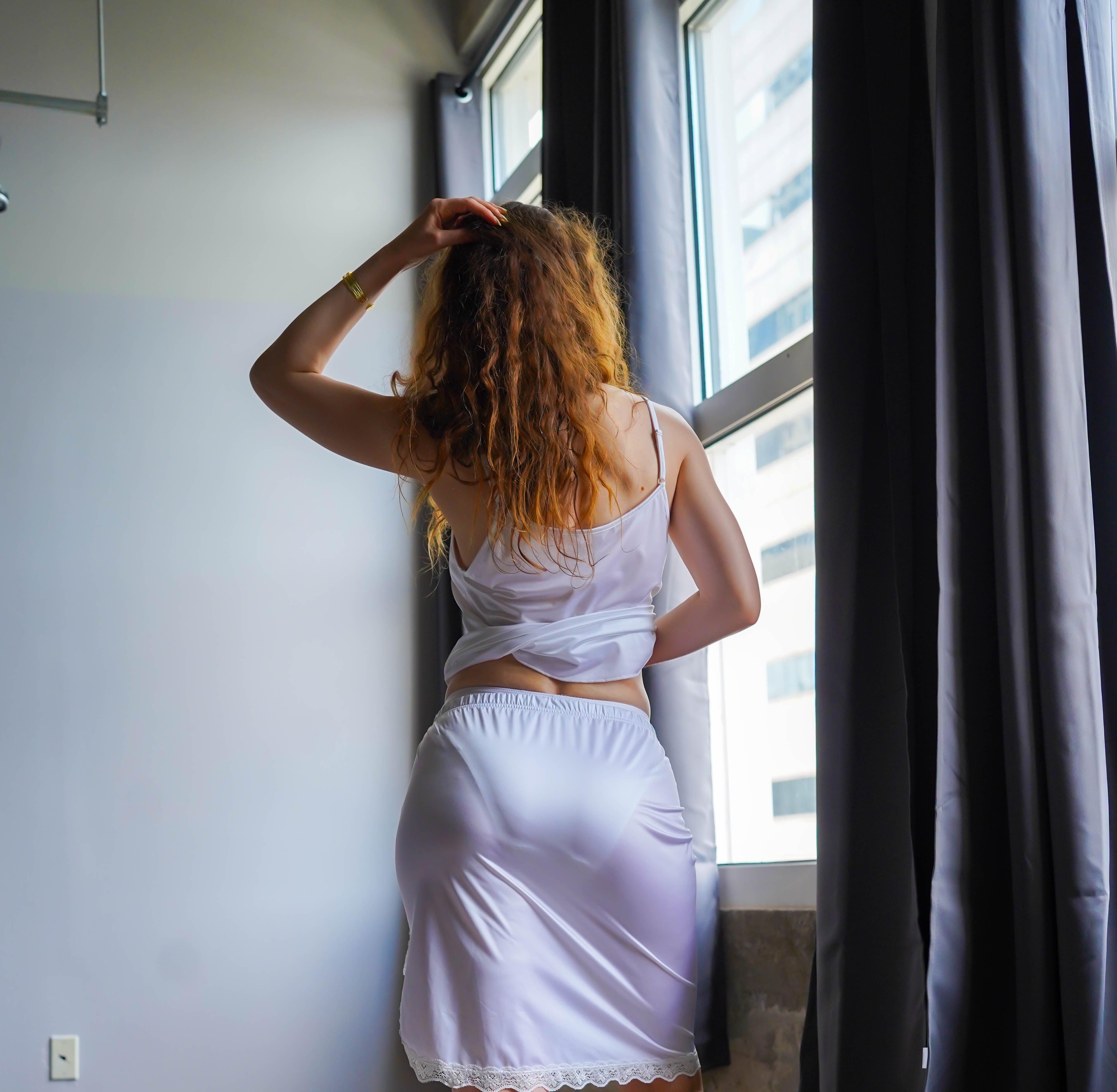 White half slip with elastic waist and lace-edged hem, back view