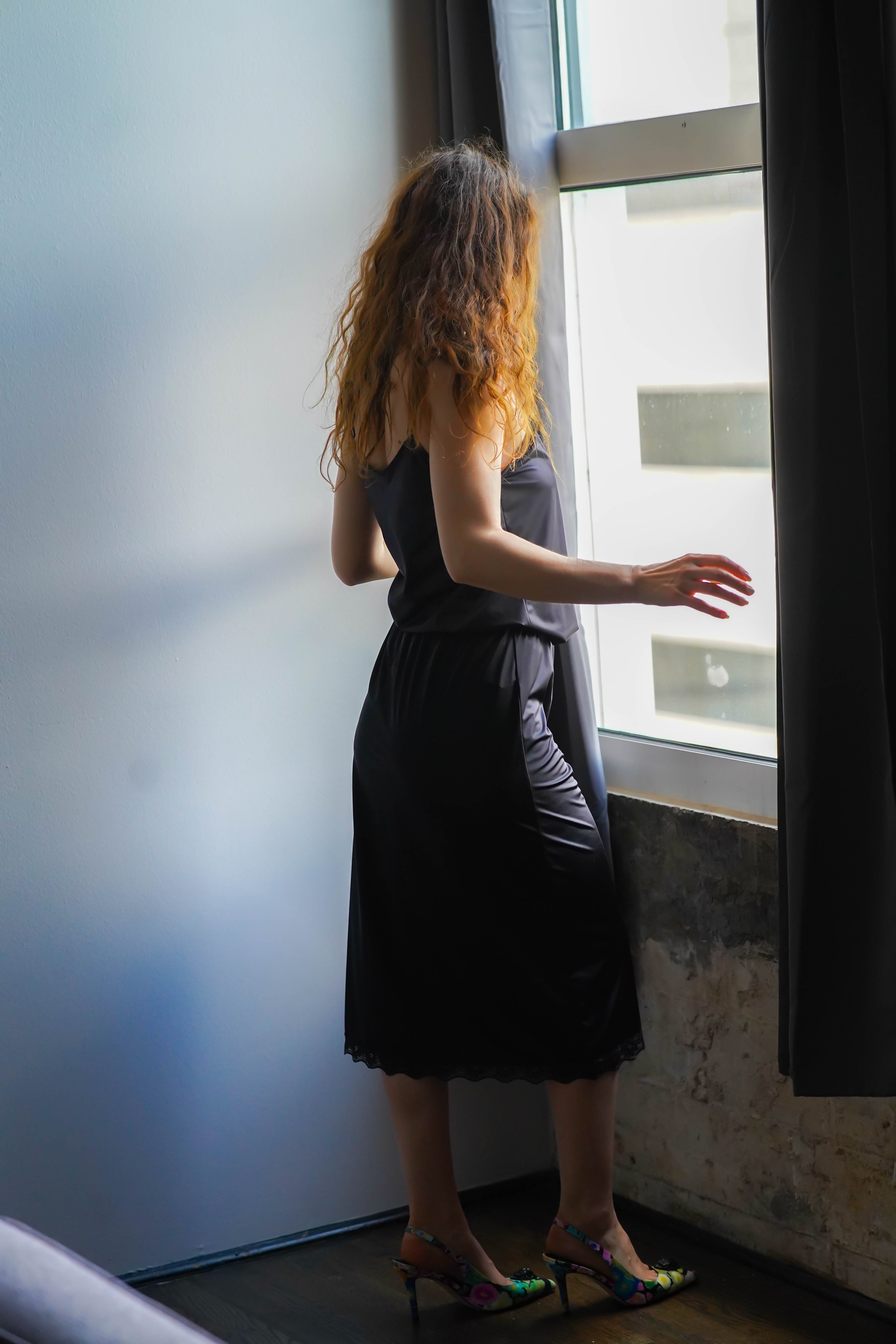 Katie half slip in midnight black satin, back view with lace-edged hem.