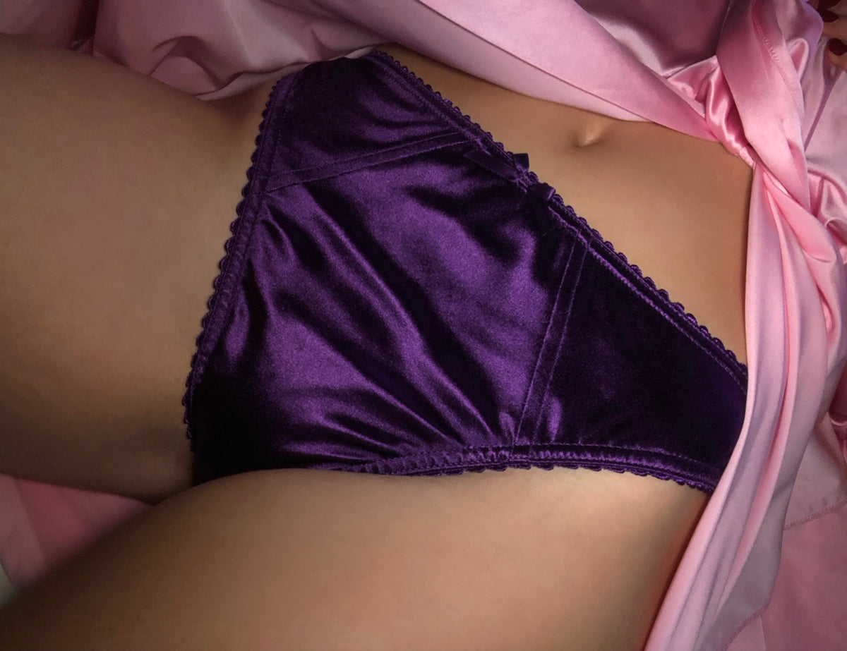Purple satin panties with lace trim, front-facing view